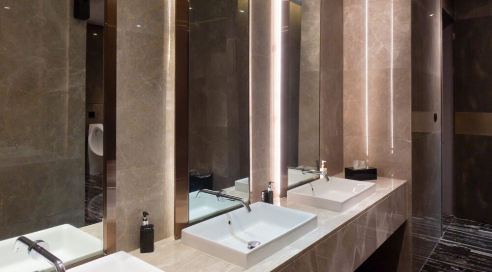 Perivni umivaonici od stakla u modernom toaletu.